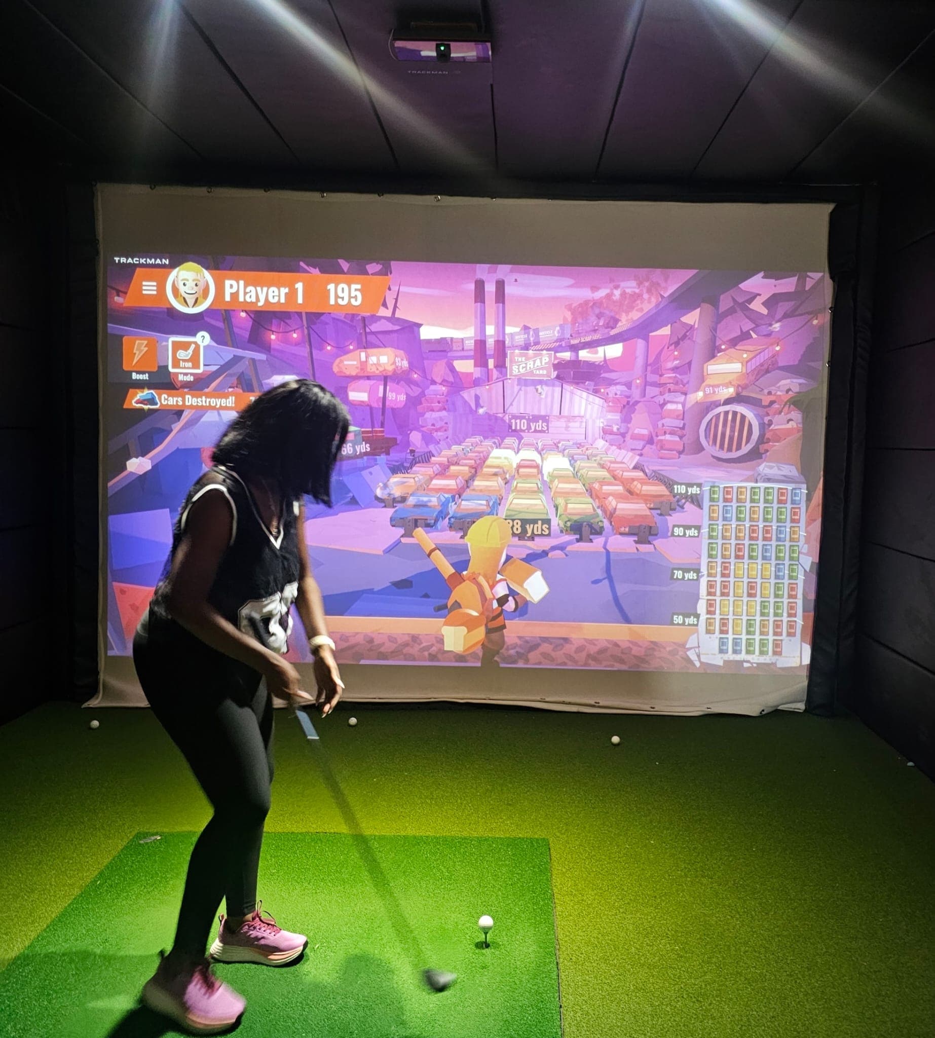 Real golfer taking a full swing in TrackMan iO bay